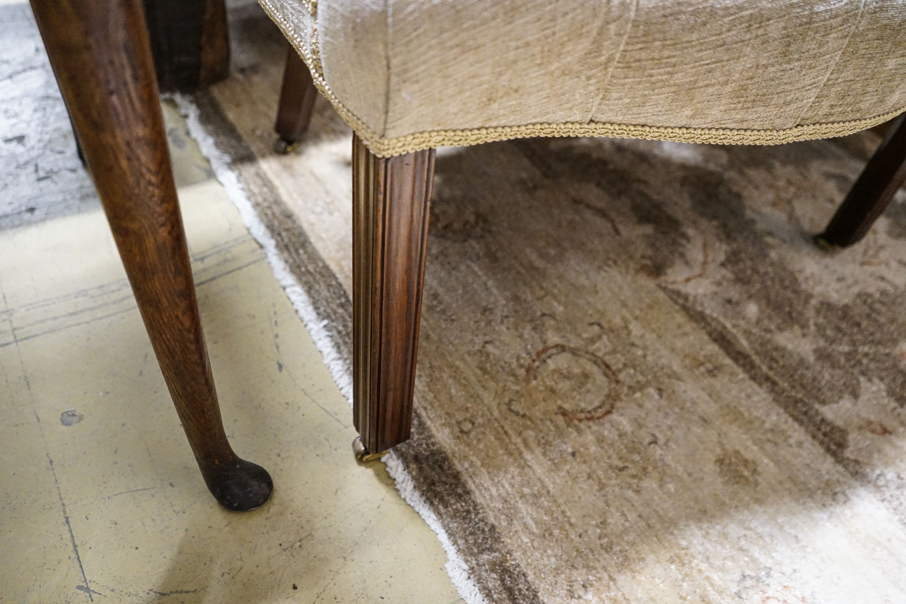 A George III Hepplewhite style mahogany tub chair, with later buttoned upholstery, acanthus carved arms and chamfered moulded squared legs, fitted brass castors, width 64cm, depth 50cm, height 97cm